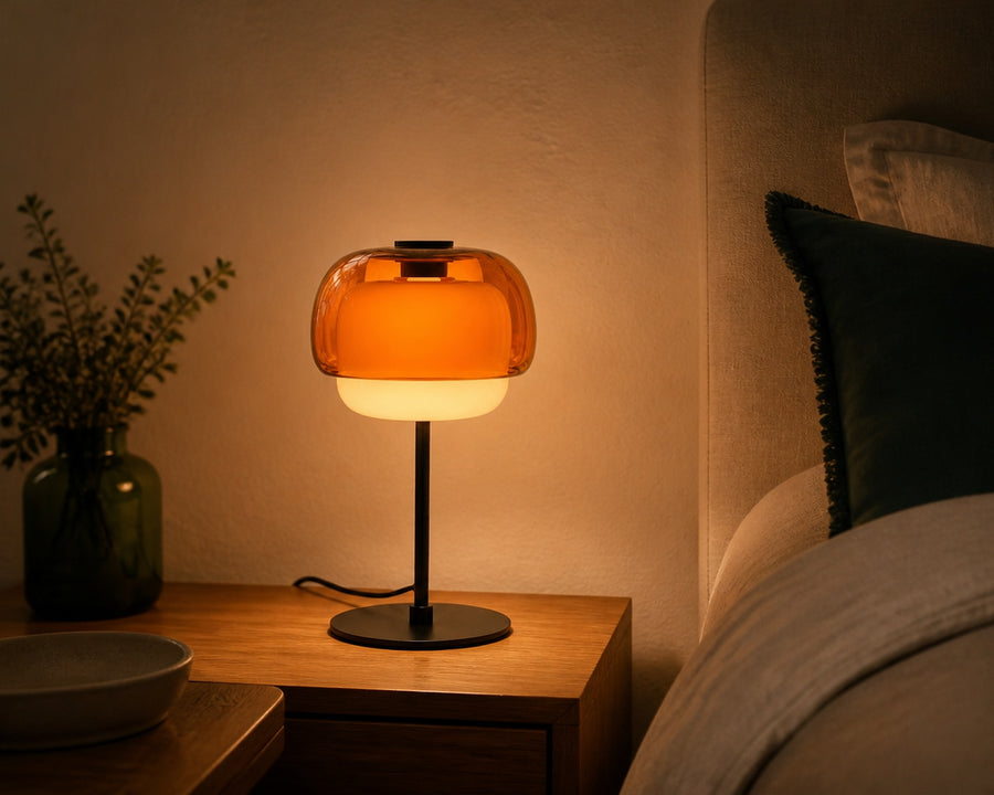 The lamp casting a soft glow on a bedside table