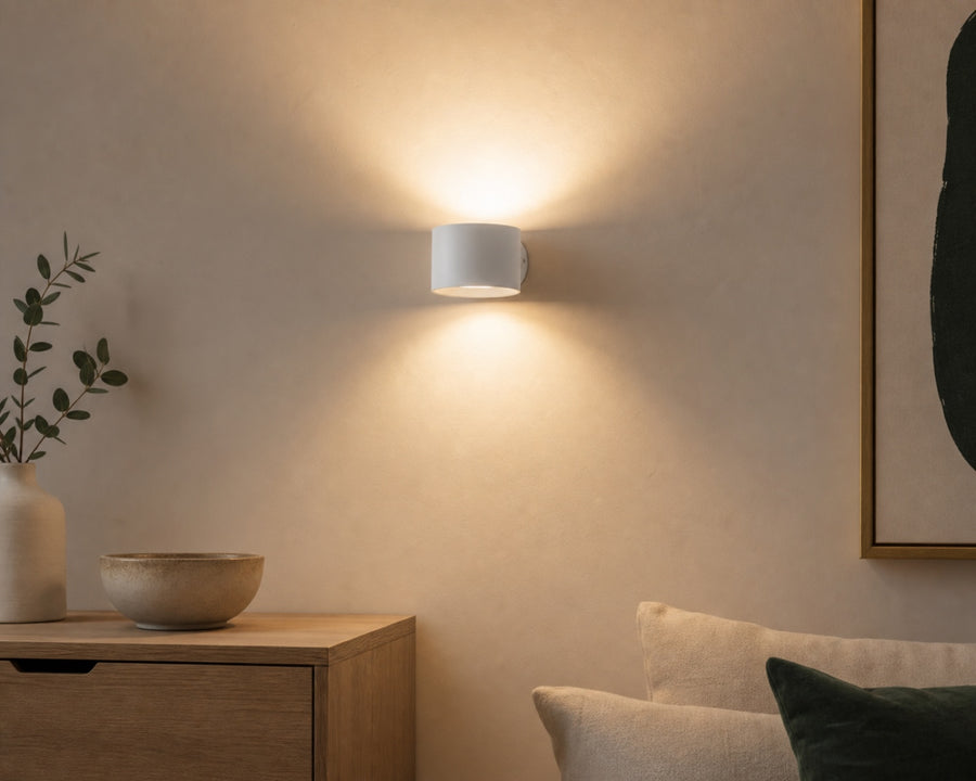 The sconce washing light up and down a wall