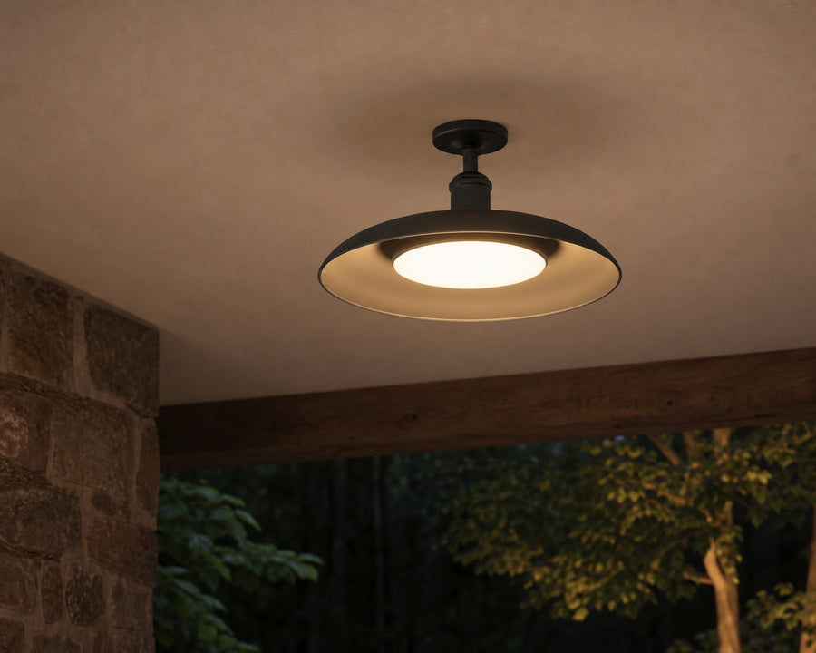 The black fixture on a covered patio ceiling, lit