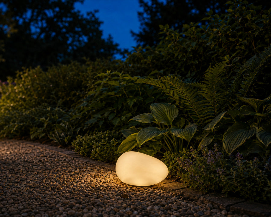 The pebble light glowing on a garden path at dusk