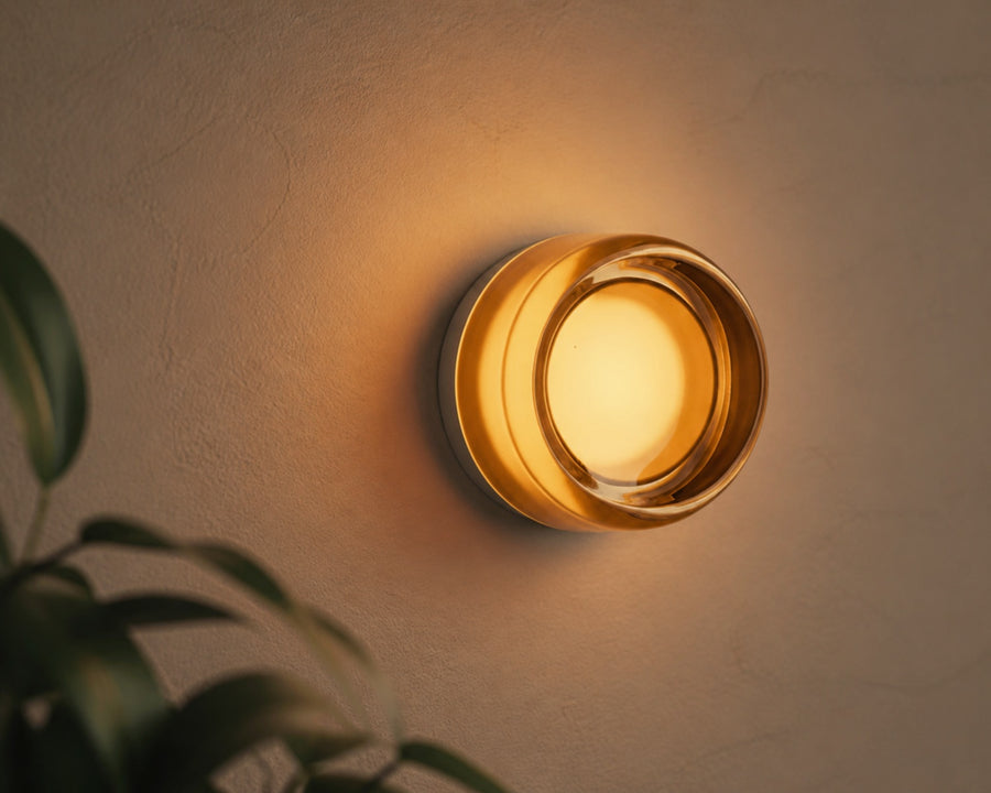 The Rondel disc sconce glowing softly on a wall