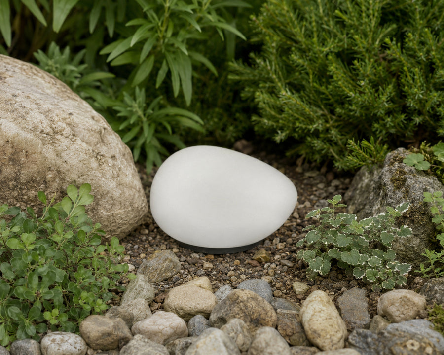 The pebble light nestled among plants in daylight