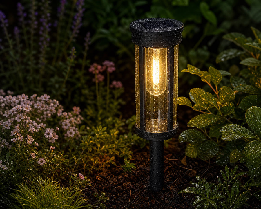 The stake light glowing in a garden bed after rain