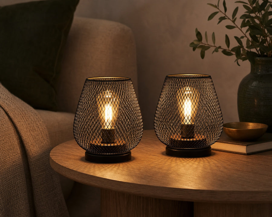 The two mesh lamps glowing together on a table